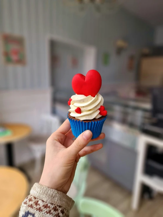 a person holding a cupcake in their hand