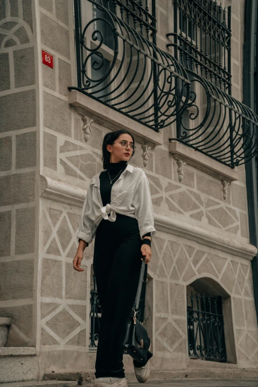 a woman is walking in front of an ornate building with balcony