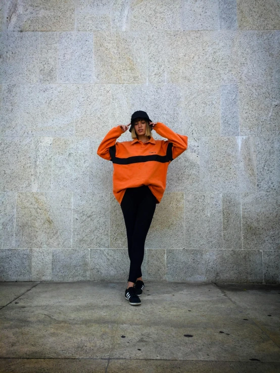 a person standing by a wall posing for a picture