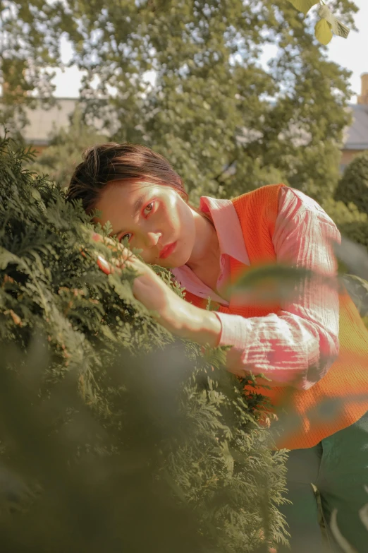 a woman is standing among some bushes