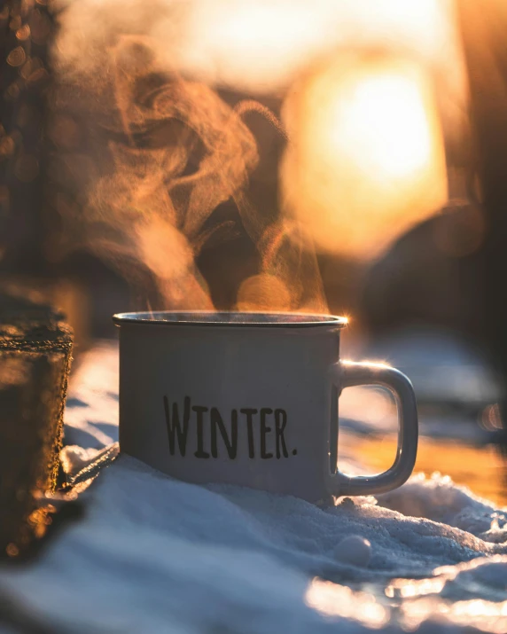 a cup with  beverages inside is sitting in the snow