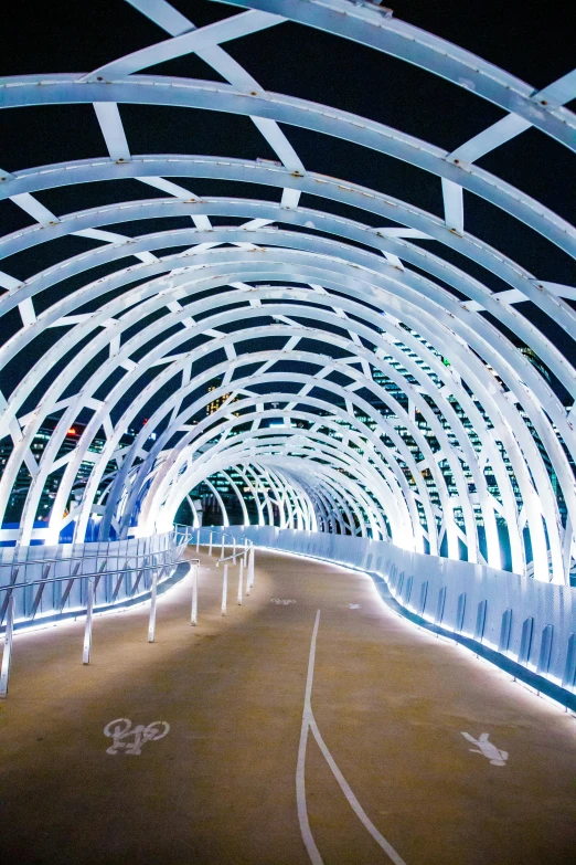 white arched walkway with metal bars and chairs at night