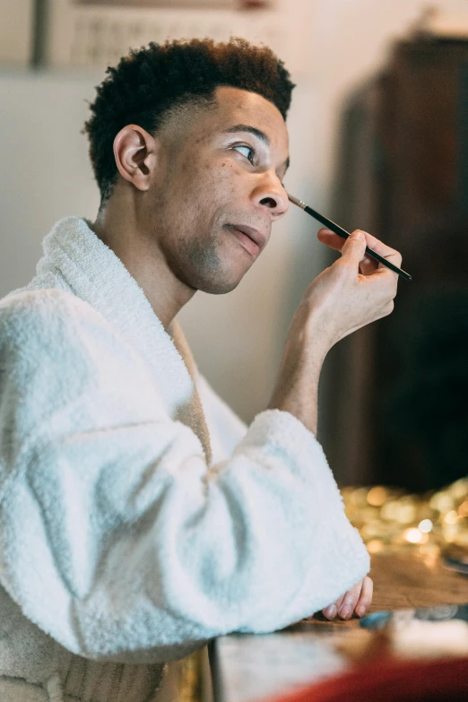 man is putting pencil in his nose with an expression