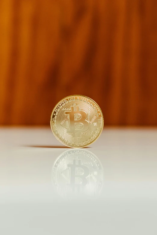 a bitcoin sits on a reflective surface in the foreground