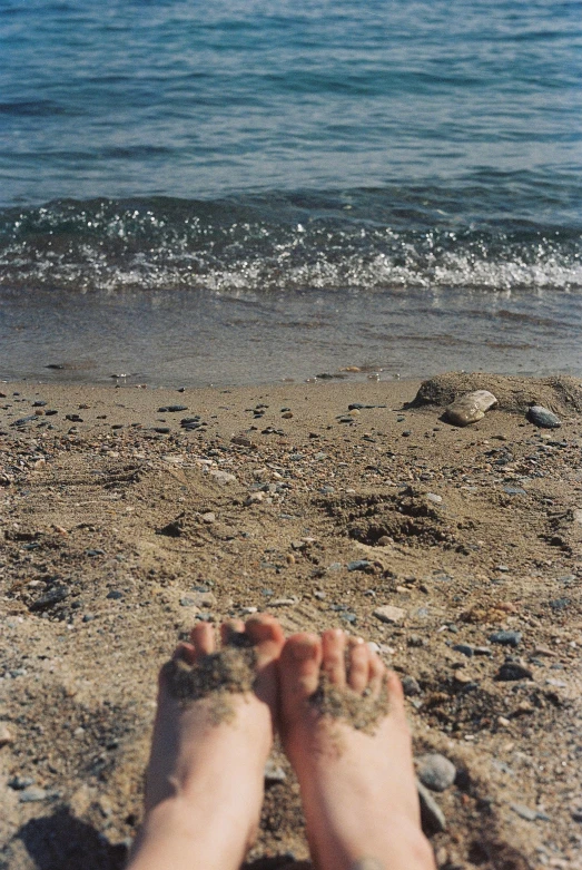 there is a persons feet at the beach