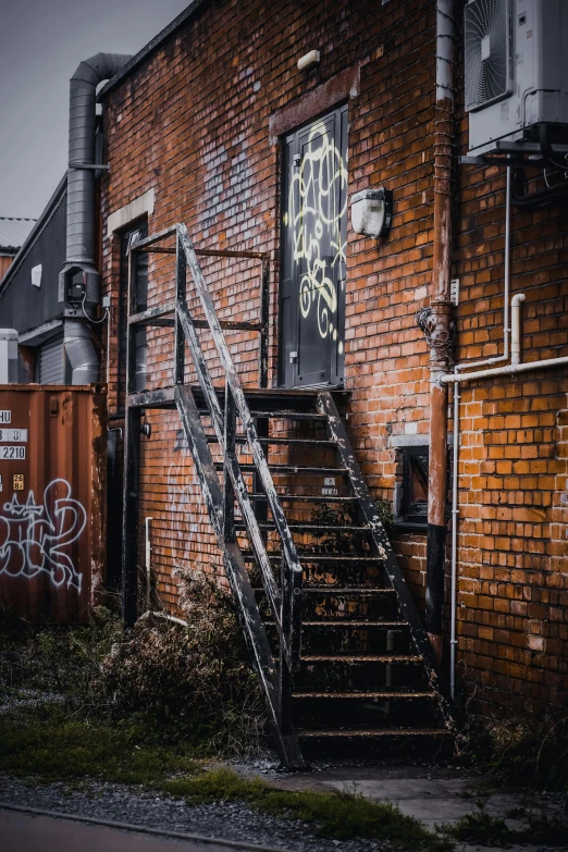 a fire escape with graffiti on the wall and stairs