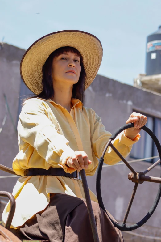 a woman wearing a straw hat driving a horse