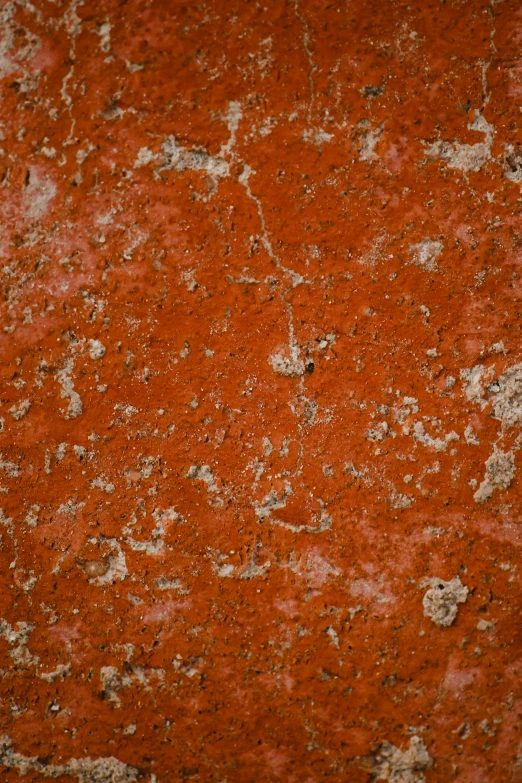 an old red wall with very little white paint and small holes