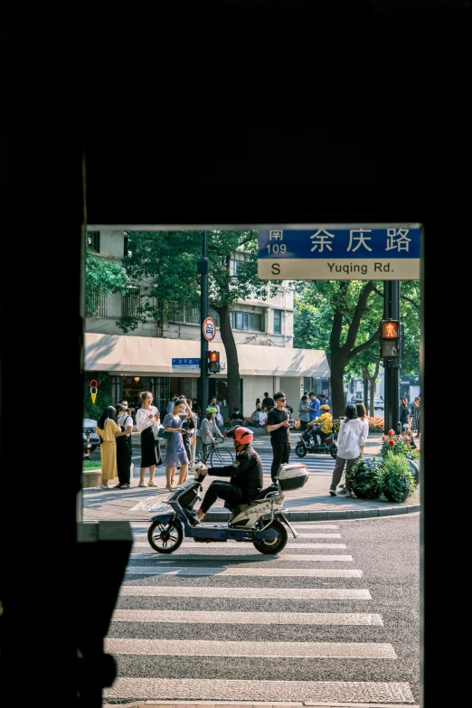 motorcycle crossing street with people at an intersection