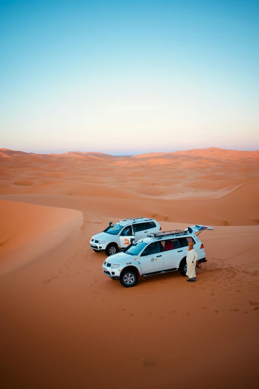 two cars parked on the sand in the desert