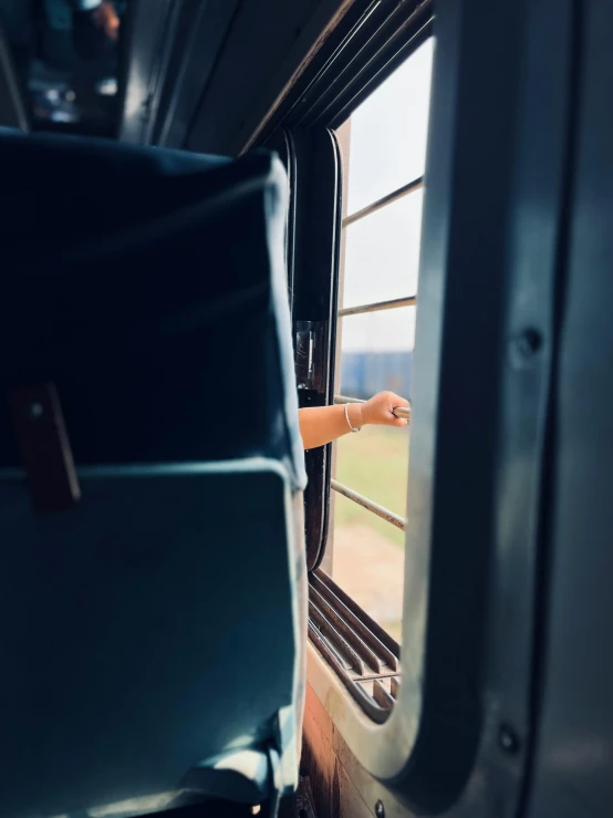 someone is looking out of the window of an empty bus