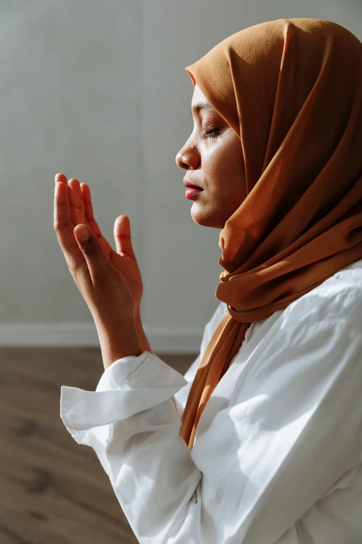 a young woman is praying while sitting down