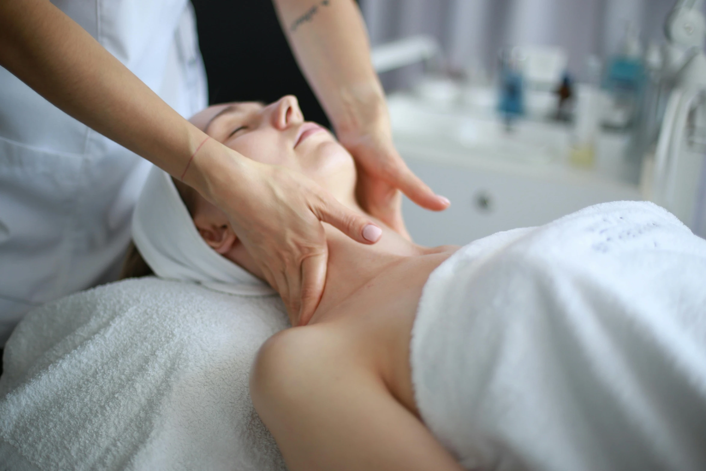 a woman getting a facial massage from someone in the bath room