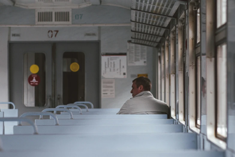 man in white jacket sitting at a long white table