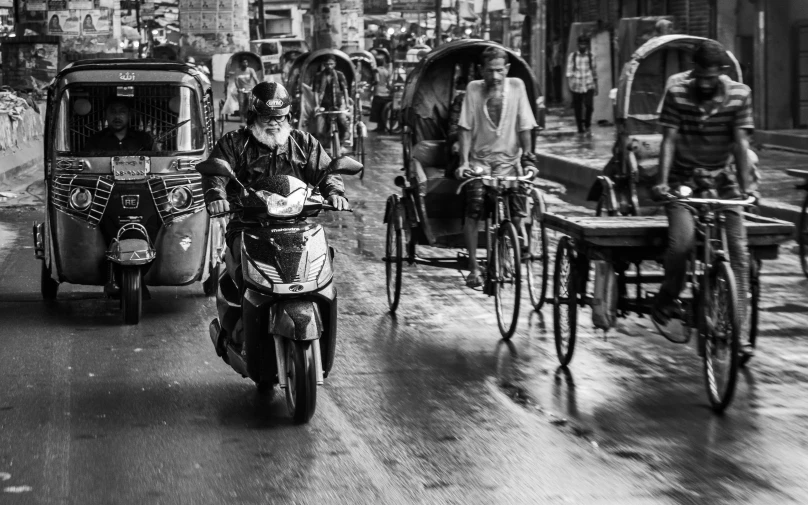 motorbikes, three rickshaws, and carriages travelling on a crowded street