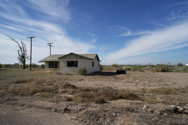 the old, run down shack sits empty by the side of a road