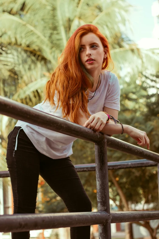 a young red haired woman leaning on the rails