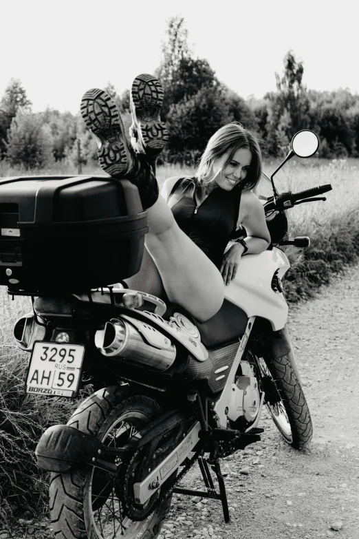 a woman on her motorcycle giving the peace sign