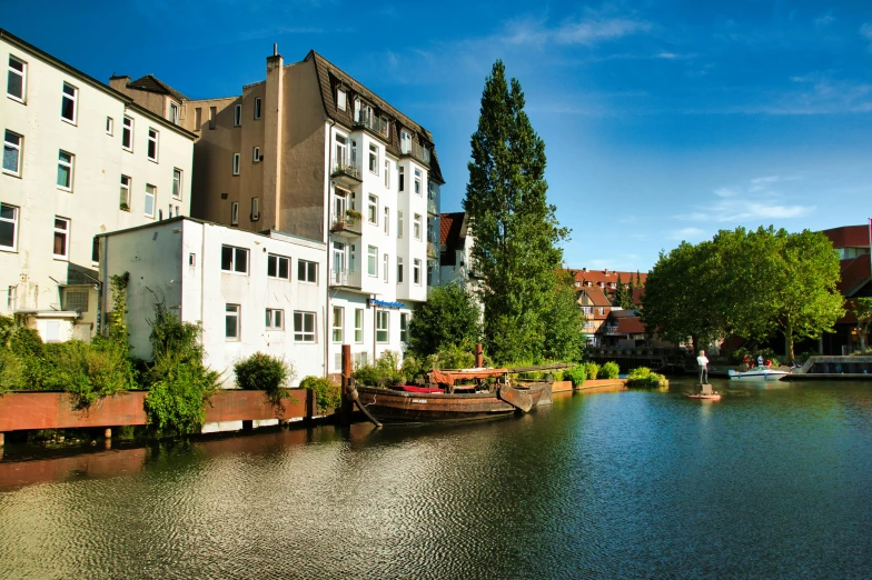 the small boat is traveling along a canal next to a city