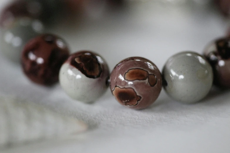 beaded celet with beads and bear paw print in light browns and cream