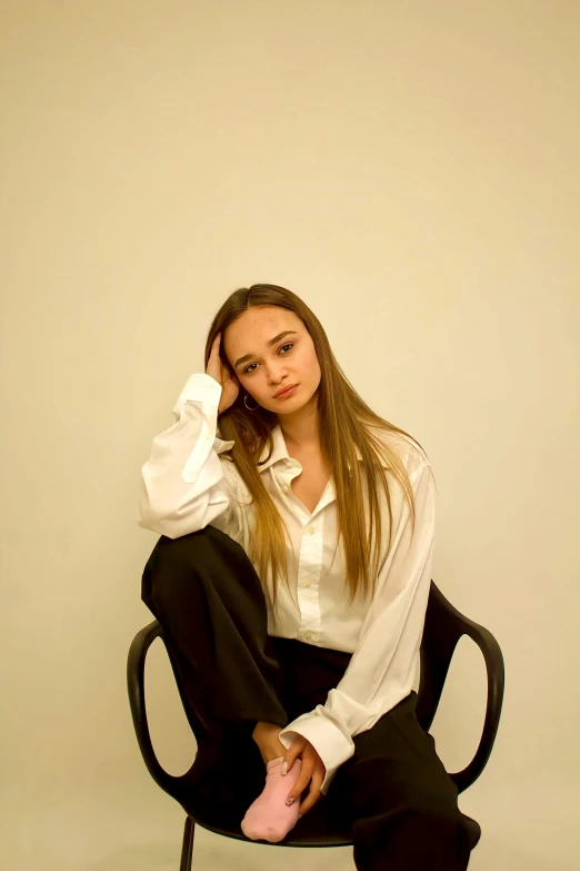 a woman sitting on a chair and talking on a cell phone