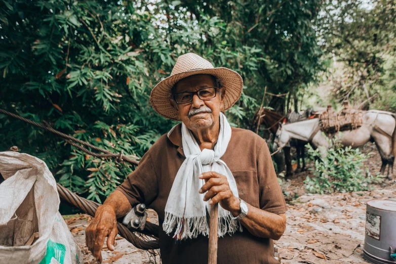 a man with a straw hat and moustache is standing outside