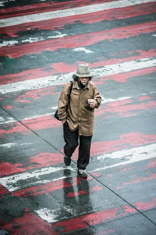 an older man stands in a parking lot in the pouring rain