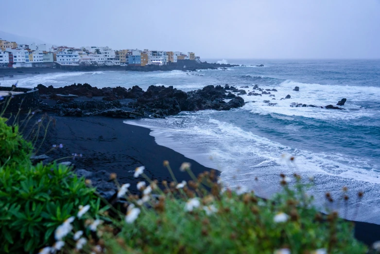 a surf boarder rides his board on a stormy day near the beach