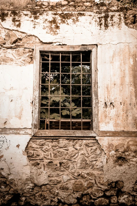 a window in an old house, with bars over it