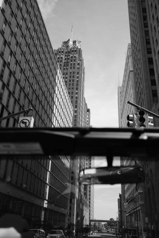looking down the street from a car in front of some very tall buildings