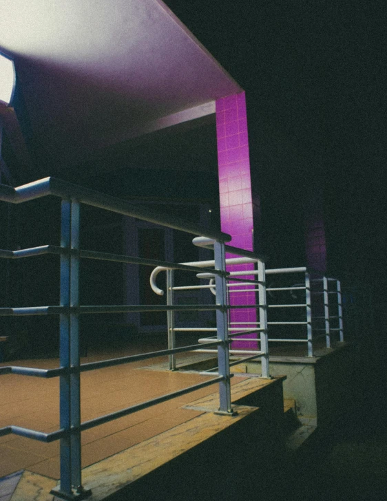 a stairway and some purple light on an empty building