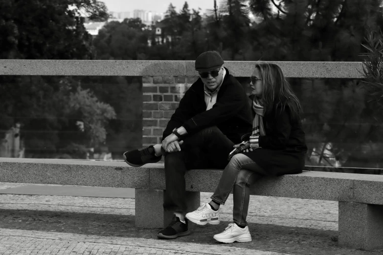 black and white pograph of two people on a bench