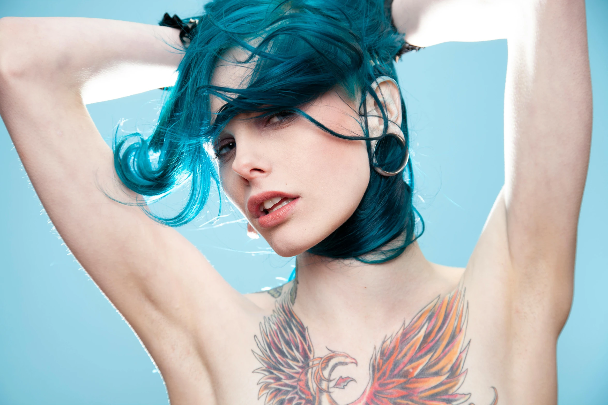 a young woman with blue hair poses 