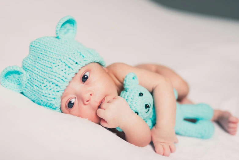 a close up of a baby laying on top of a bed