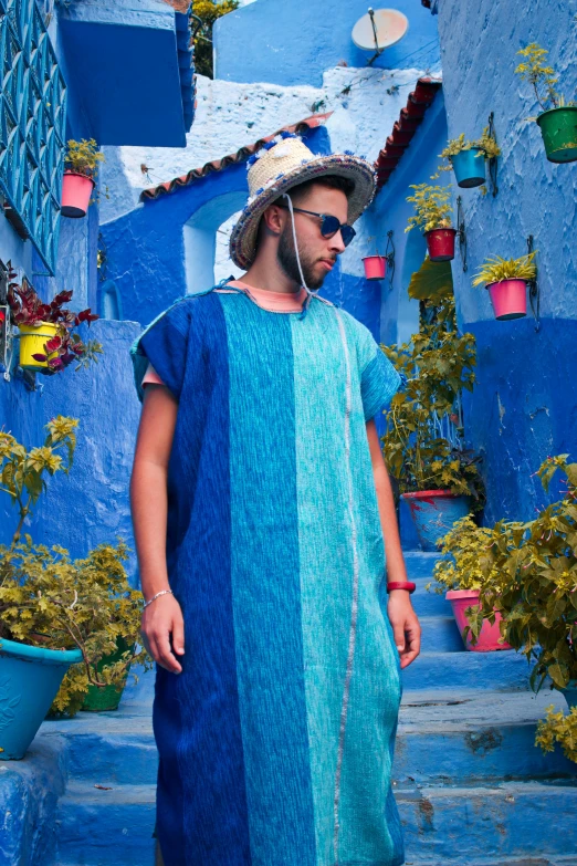 a man wearing headphones standing in front of blue buildings