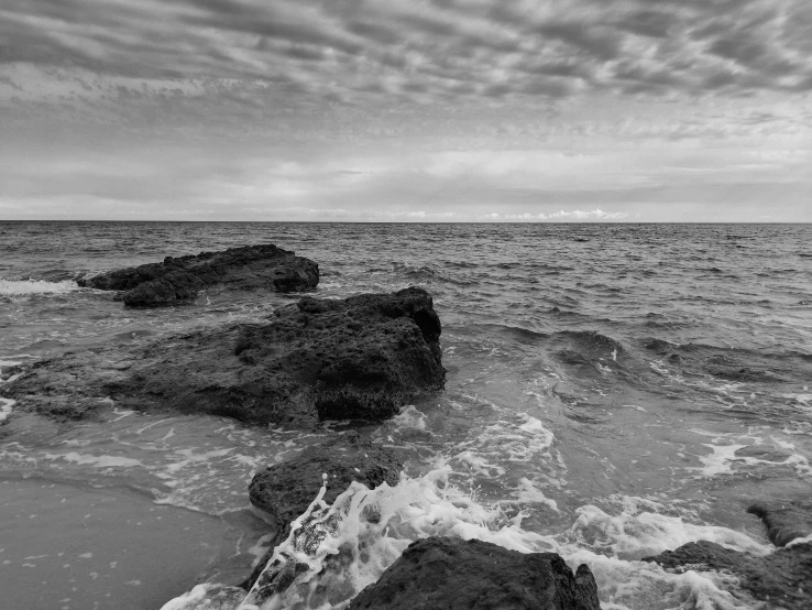 rocks and sea water during a cloudy day