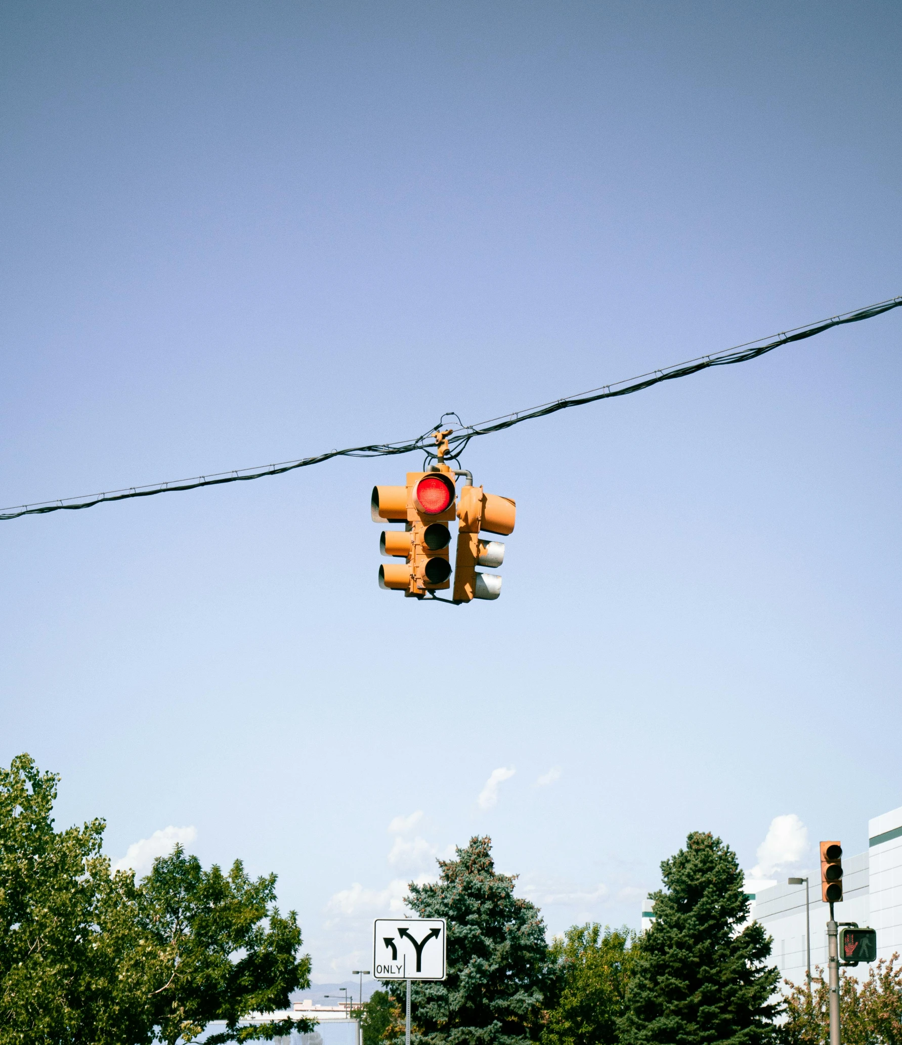 the traffic light is hanging on the power lines