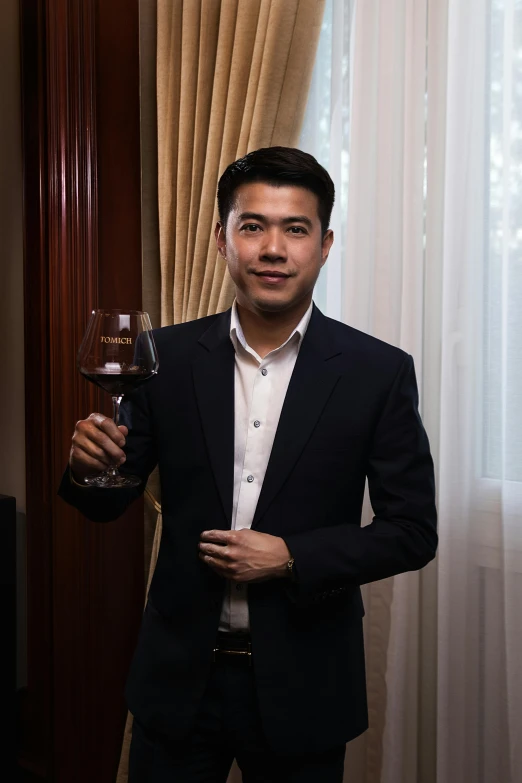 a man in a suit holding a glass of wine
