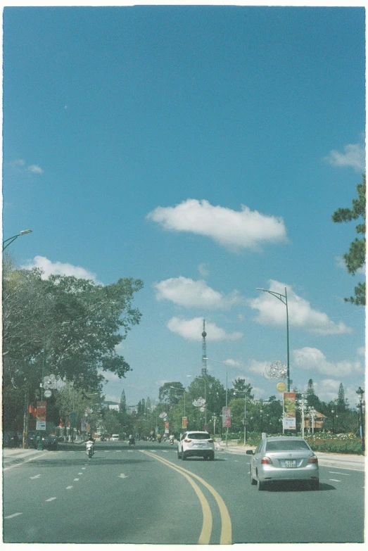 a street scene with cars on the road and blue sky