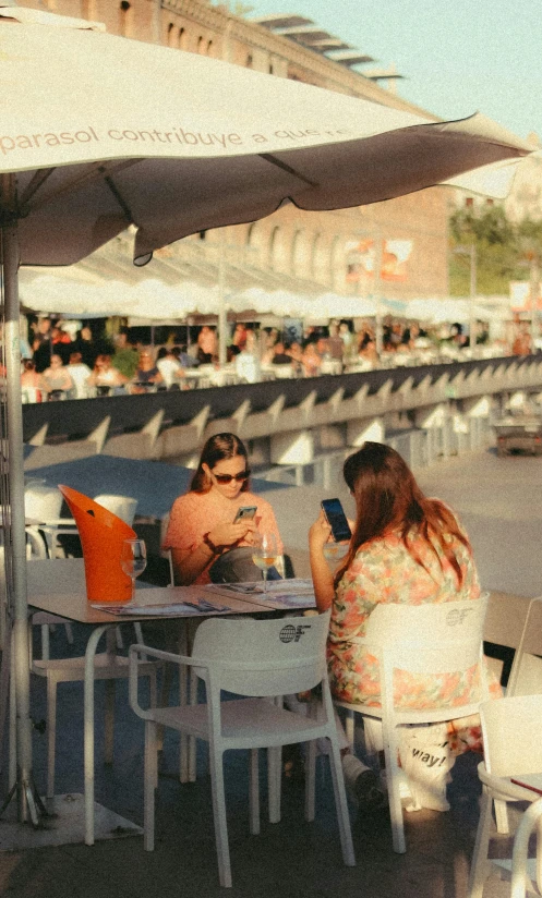 two people sitting at a table in a city