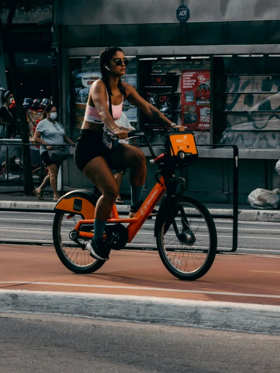 a girl rides her bike on the sidewalk