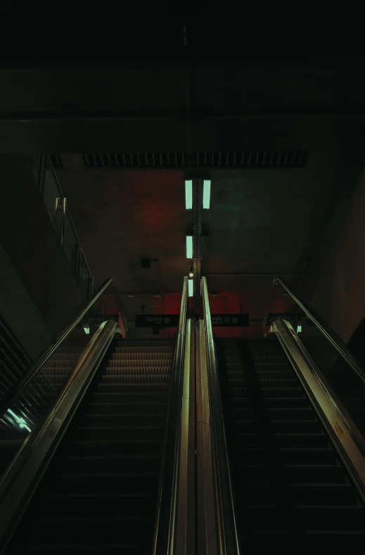 two escalators are shown in a darkened place