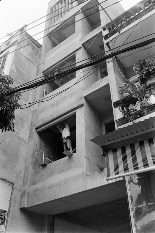 a person in a window sill of a tall building