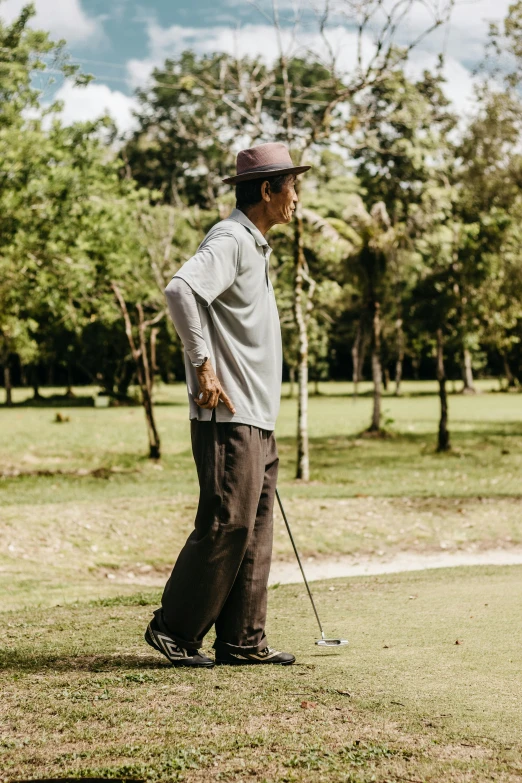 a man is standing on the grass with his golf club in hand