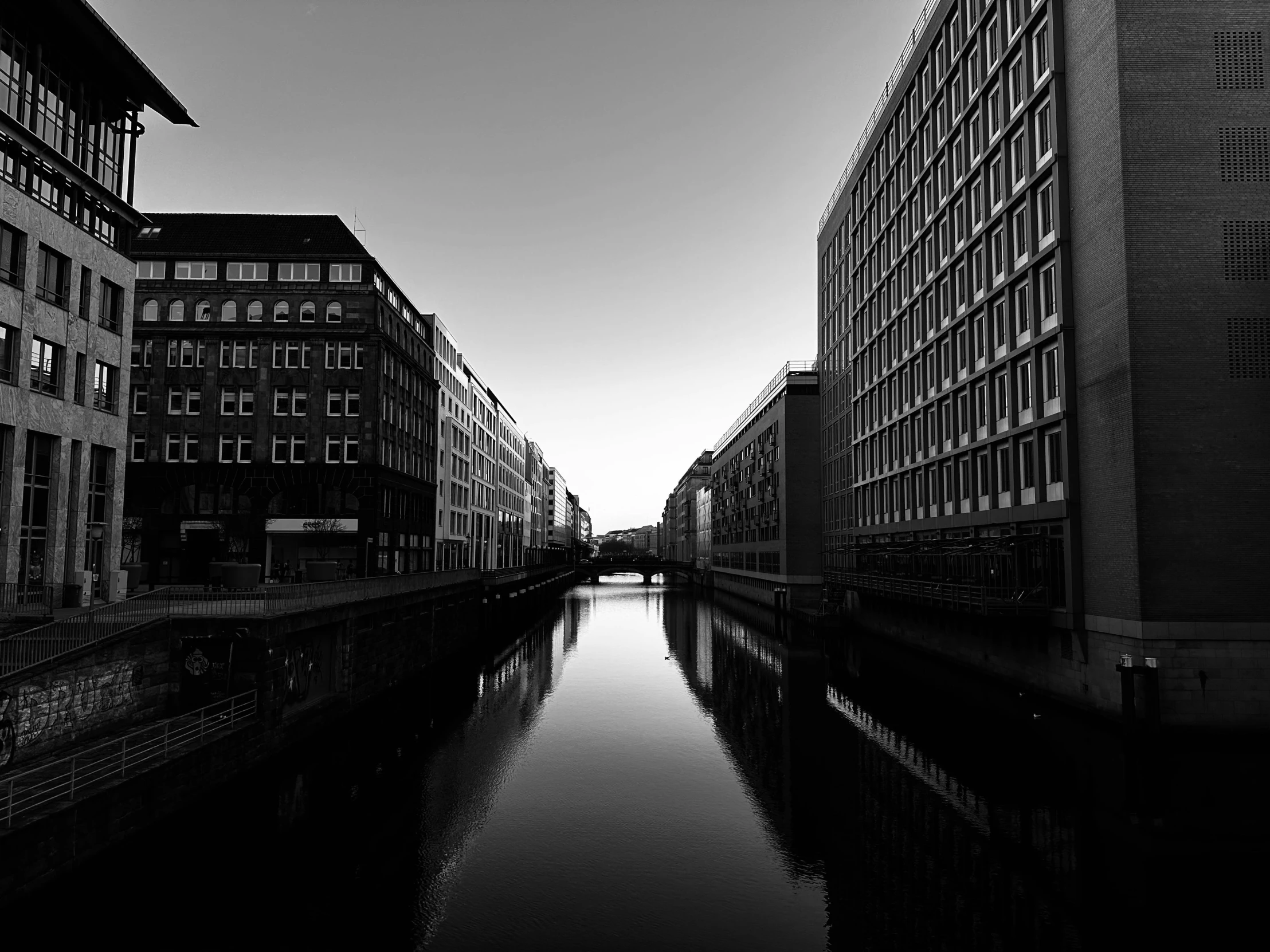 black and white pograph of a waterway with old buildings and houses