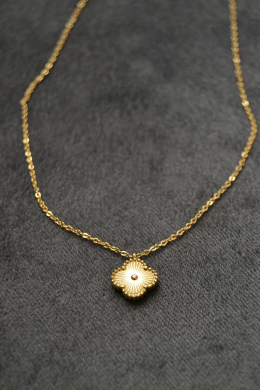 a gold necklace has a flower on it