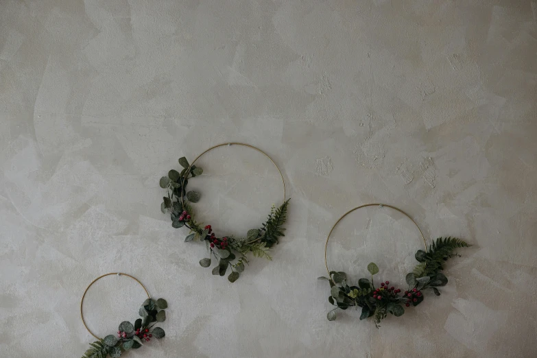 3 wreathed hoop earrings sitting on a gray surface