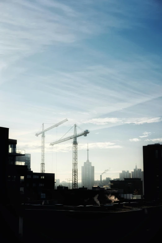 a cityscape with cranes and other buildings