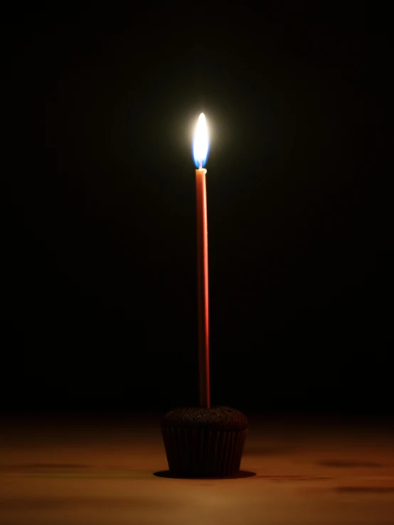 a single candle that is lit in the dark