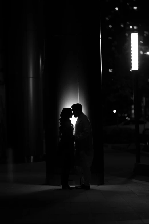 two people stand in the middle of a city street